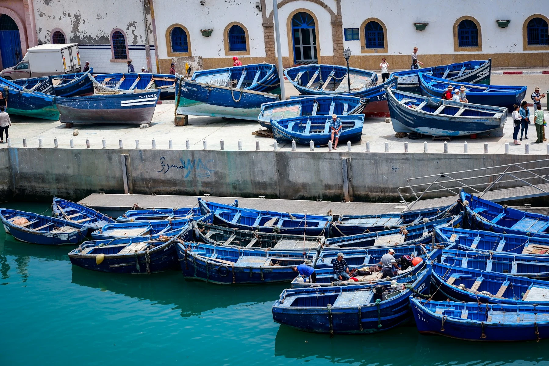 Barcos de pesca azuis junto às muralhas do porto de Essaouira