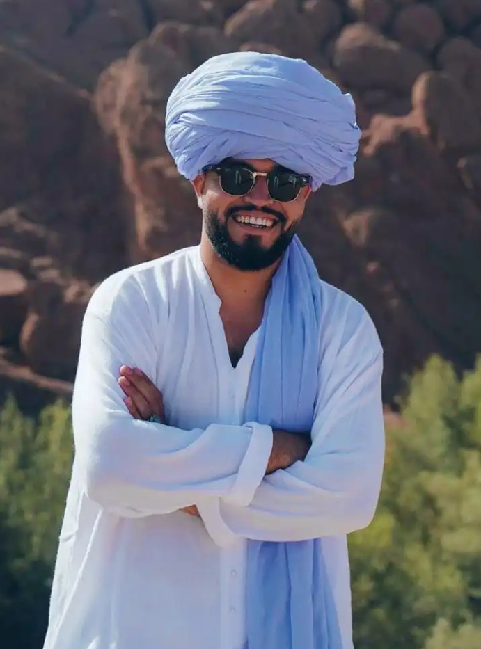 Hassan Mezane com turbante azul-claro ao ar livre